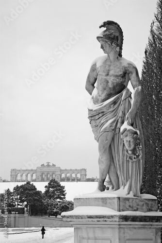 Vienna - Gloriette in Schonbrunn palace and statue from mythology in winter