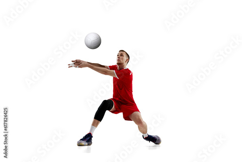 Serving ball. Young concentrated man, professional volleyball player in red uniform in motion against white studio background. Concept of sport, active lifestyle, health, dynamics, game, ad © master1305