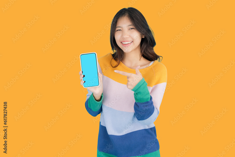 Beautiful young woman smiling happily while holding a Smartphone in her hand Beautiful young woman smiling happily while holding a Smartphone in her hand