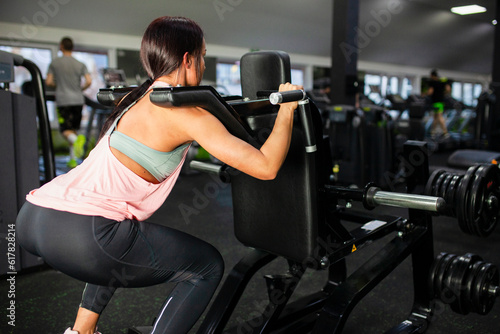 Female workout on leg mashine in the gym