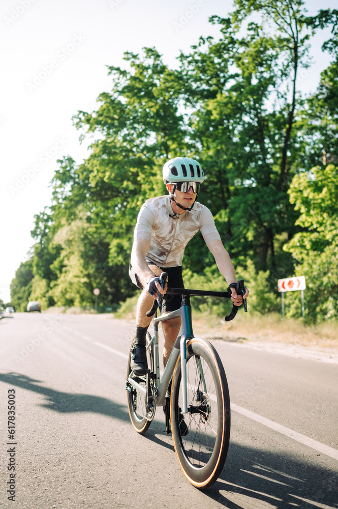 Vertical photo of a man on a bicycle in sports equipment riding in the city on the road and exercising. Vertical photo of a man on a bicycle in sports equipment riding in the city on the road and exercising.