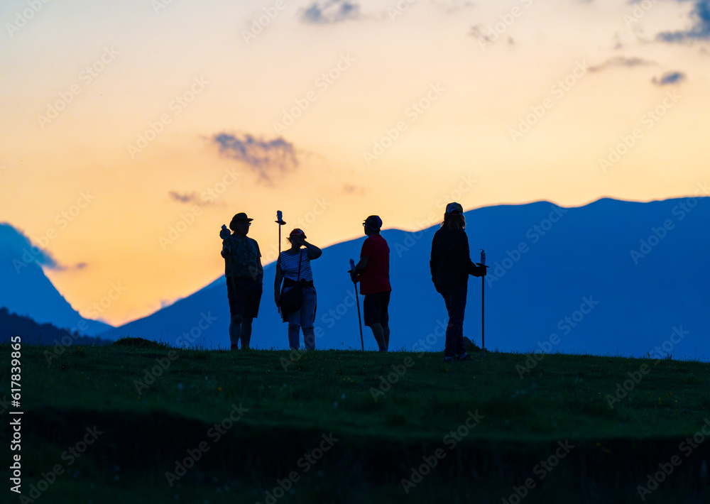 Obraz premium Silueta de 4 personas en la montaña en el atardecer