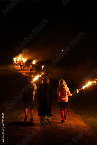 Personas en fila portando antorchas en llamas