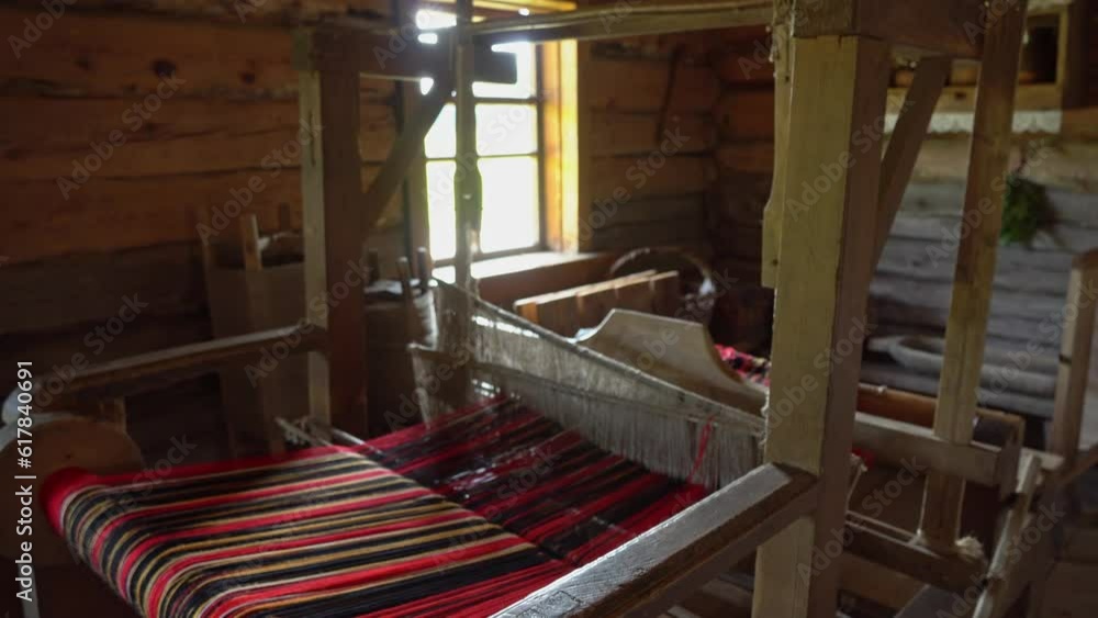 Ancient loom inside an old hut, a knitting and spinning machine. An old manufactory for the production of belts, towels and clothes Ancient loom inside an old hut, a knitting and spinning machine. An old manufactory for the production of belts, towels and clothes