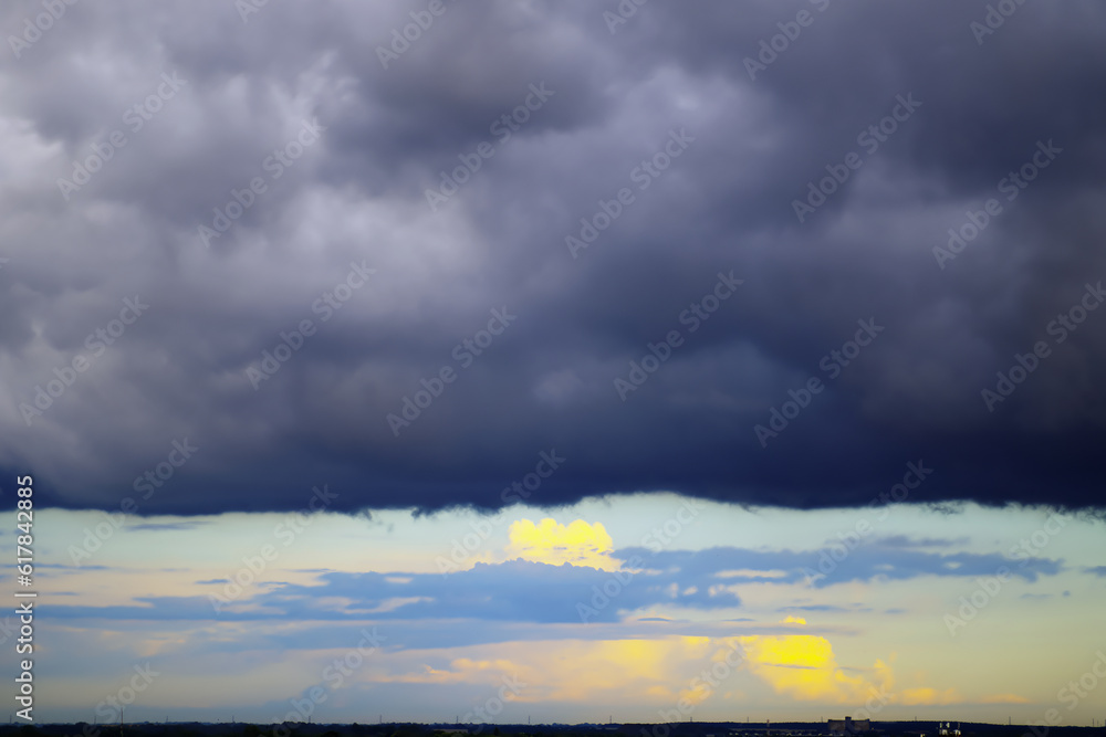 black storm clouds over the city during the setting sun