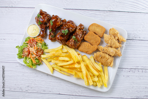 Obraz na płótnie Chicken mix, wings in bbq sauce, nuggets and chicken pieces, accompanied by French fries, salad and mayonnaise w salonie
