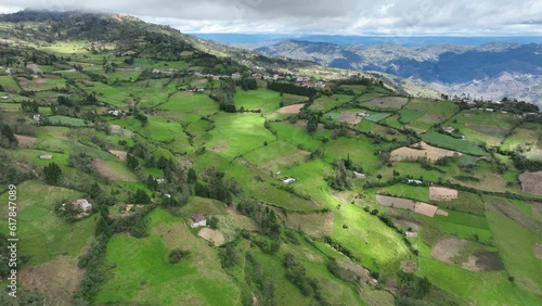 Aerial view of mountains, grasslands and small townin the Andes, Andean or Sierra geographical region of the Peru that extends from north to south through the Cordillera de los andes. photo