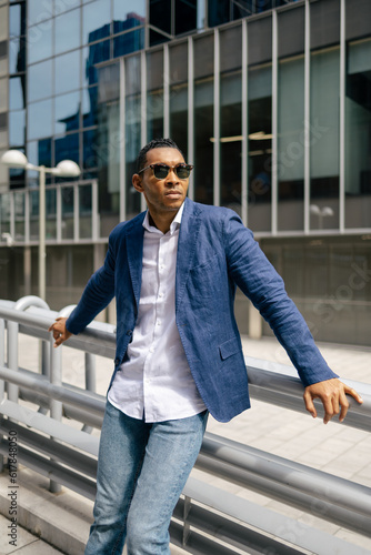 Portrait of stylish man leaning against the railing