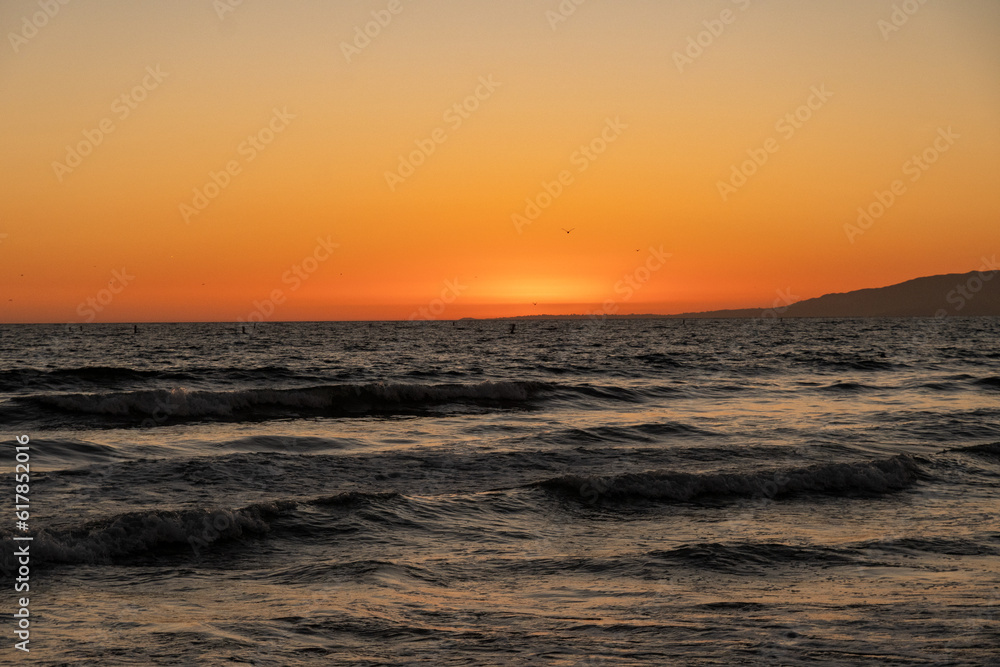 Ocean waves and the sunset at Santa Monica Beach, in Santa Monica California.