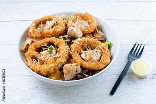Obraz na płótnie Bowl salad with pieces of roast pork, grated cheese, onion rings and house mayonnaise w salonie
