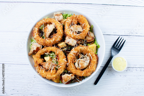 Obraz na płótnie Bowl salad with pieces of roast pork, grated cheese, onion rings and house mayonnaise w salonie