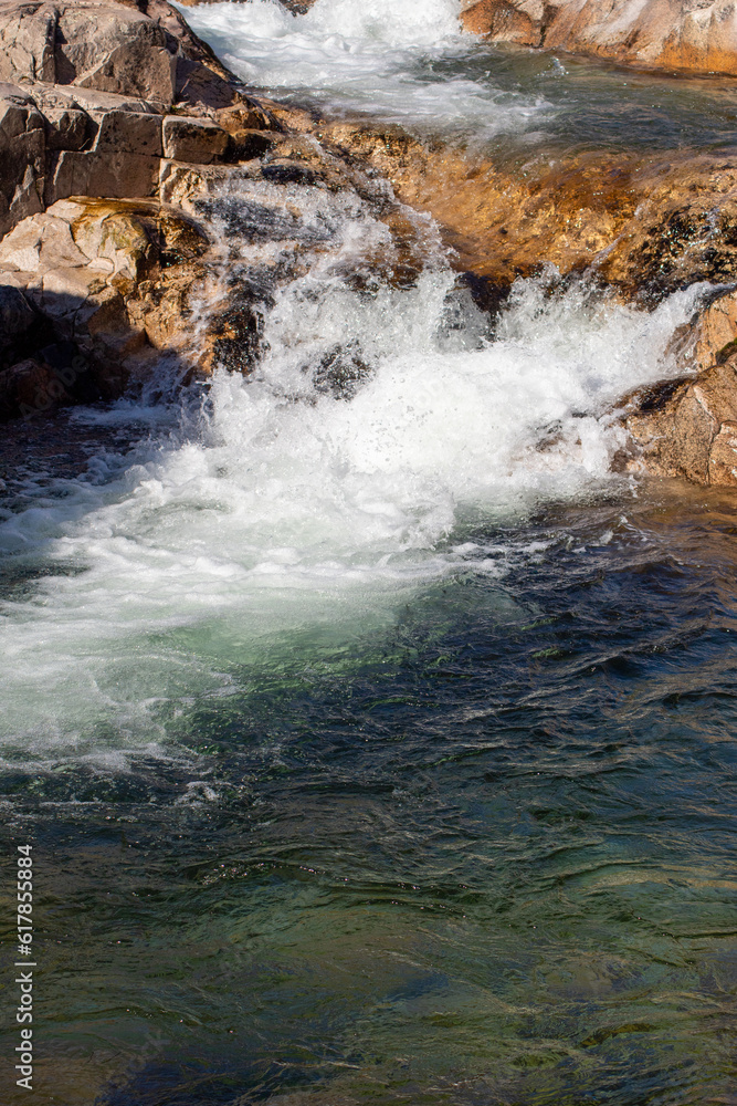 Fotografía del río de La Pedriza con una cascada y aguas cristalinas: La imagen muestra el río de La Pedriza fluyendo suavemente entre las rocas, con una hermosa cascada en el fondo. 