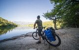 A tourist on an electric trekking bike admires the view of Lake Monticolo in northern Italy