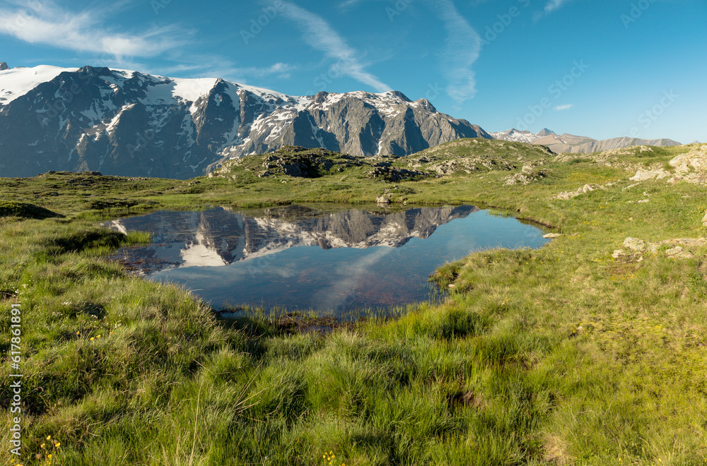reflet des glaciers de la Meije sur un lac du plateau d'Emparis au refuge des Mouterres dans les Alpes en été