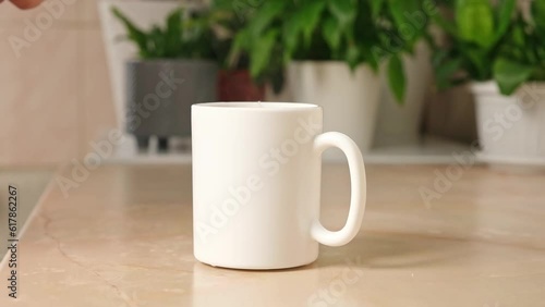 Wallpaper Mural A man puts three teaspoons of sugar in a white teacup with a tea bag and hot water to make himself tea in the kitchen. Break. Torontodigital.ca