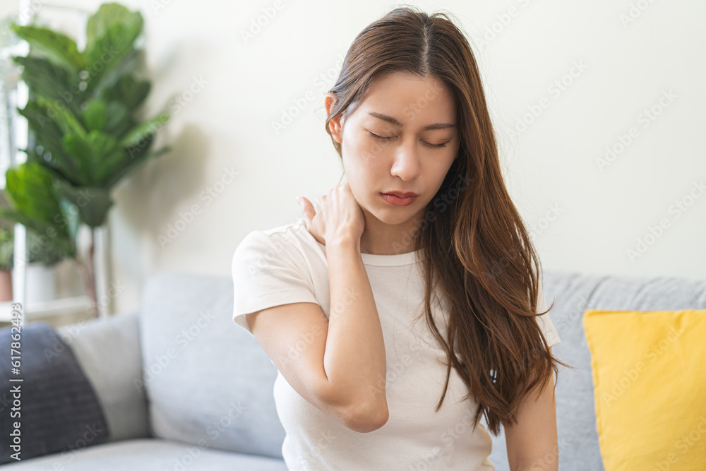 Pain body muscles stiff problem, asian young woman, girl painful with back, neck ache from work hand holding massaging rubbing shoulder hurt, sore sitting on couch at home. Health care and medicine. Pain body muscles stiff problem, asian young woman, girl painful with back, neck ache from work hand holding massaging rubbing shoulder hurt, sore sitting on couch at home. Health care and medicine.