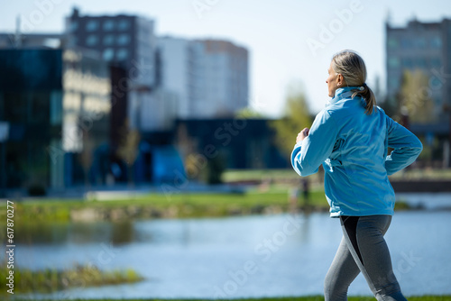 Woman in blue blazer running in th morning park