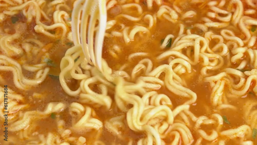 Mixing spices in done Instant noodles in a bowl rotate on wooden background, Asian sweet and sour noodles Mixing spices in done Instant noodles in a bowl rotate on wooden background, Asian sweet and sour noodles