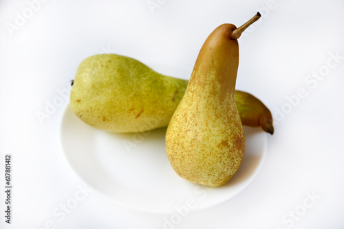 Fresh fruit. Green pear on a white plate. Chopped pear.