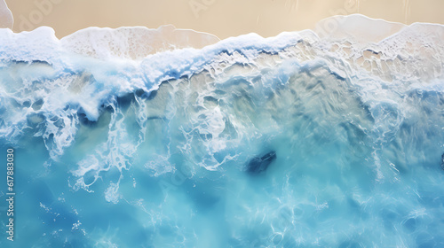 Satellite view of a beach with blue water, white waves and golden sand