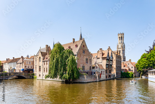 The Quay of the Rosary (Rozenhoedkaai) canal in Bruges with the classic medieval buildings and the Belfry Tower of Bruges in the background, Belgium