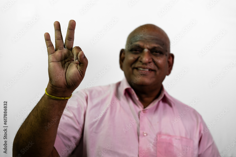 South Indian old bald man defocused saying super in front of camera and finger focused on White Background South Indian old bald man defocused saying super in front of camera and finger focused on White Background