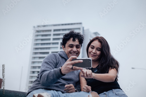 Photograph of a young couple looking attentively at a cell phone. Lifestyle concept, convenience and couples.