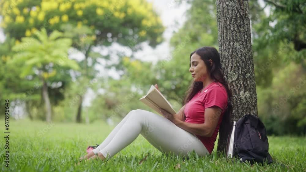 leisure in nature and trees. profile of woman in pink shirt reading book in lush forest. leisure in nature and trees. profile of woman in pink shirt reading book in lush forest.