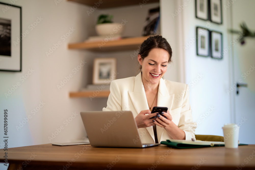 Attractive young woman using mobile phone and laptop and working at home Attractive young woman using mobile phone and laptop and working at home