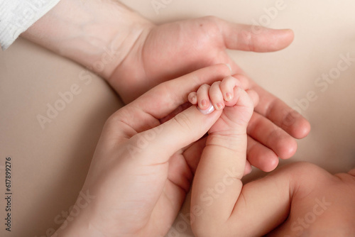 newborn baby holds mom's finger. hand of a newborn baby in the hands of parents © Svetlana