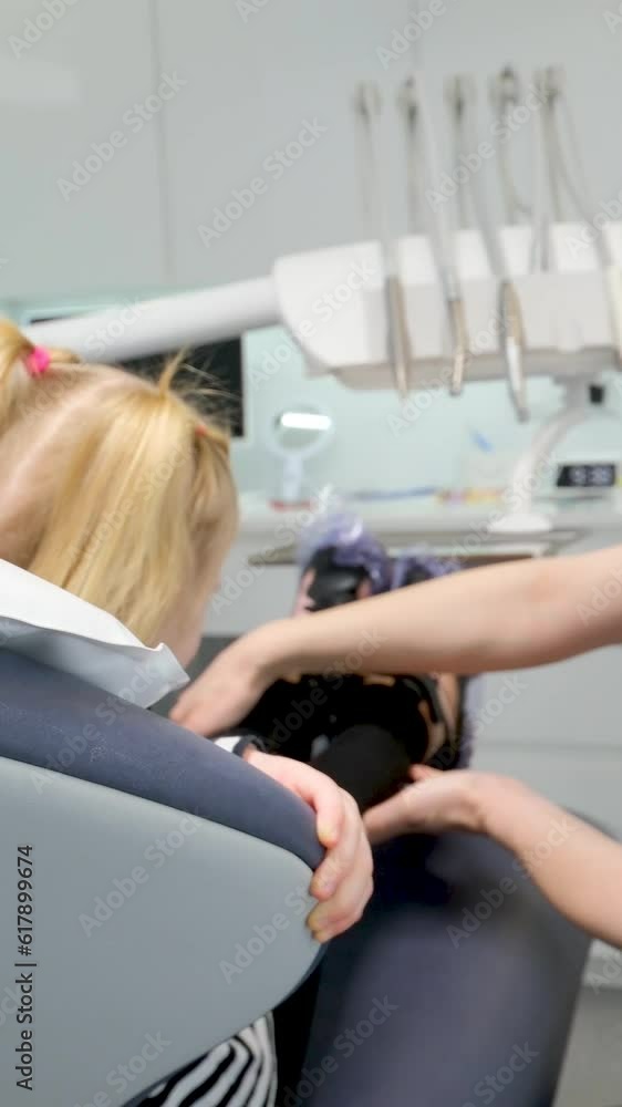 young doctor showing little girl dental chair first trip to dentist happy happiness smile pleasant conversation milk teeth treatment nurse fair-haired girl child young doctor showing little girl dental chair first trip to dentist happy happiness smile pleasant conversation milk teeth treatment nurse fair-haired girl child