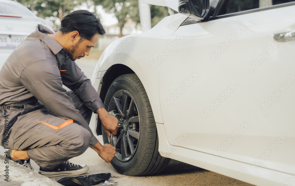 Fototapeta premium car service, repair, maintenance concept - Asian auto mechanic man or Smith writing to the clipboard at workshop warehouse, technician doing the checklist for repair machine a car in the garage,banner
