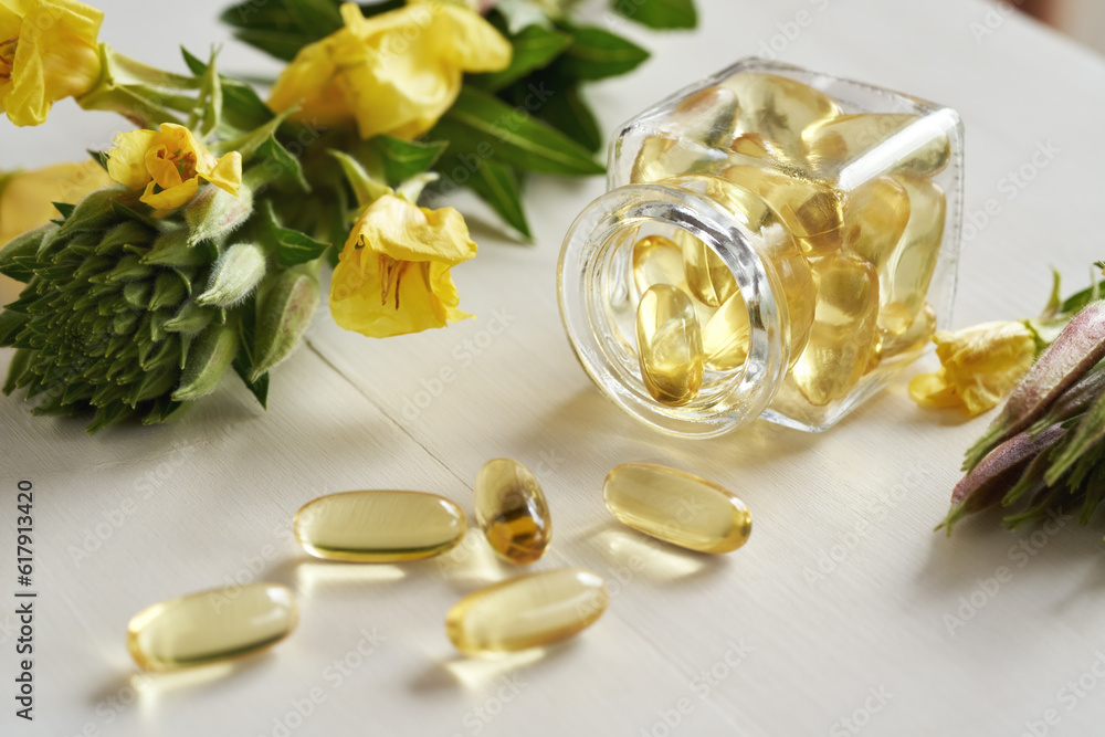 Gel capsules of evening primrose oil spilled from a glass bottle Gel capsules of evening primrose oil spilled from a glass bottle