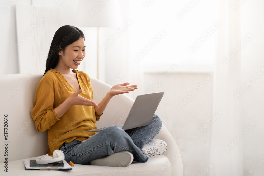Positive asian woman working from home, using laptop Positive asian woman working from home, using laptop