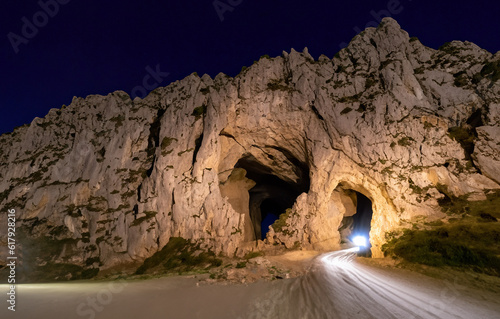 beautiful illuminated cave in the middle of a mountain at night