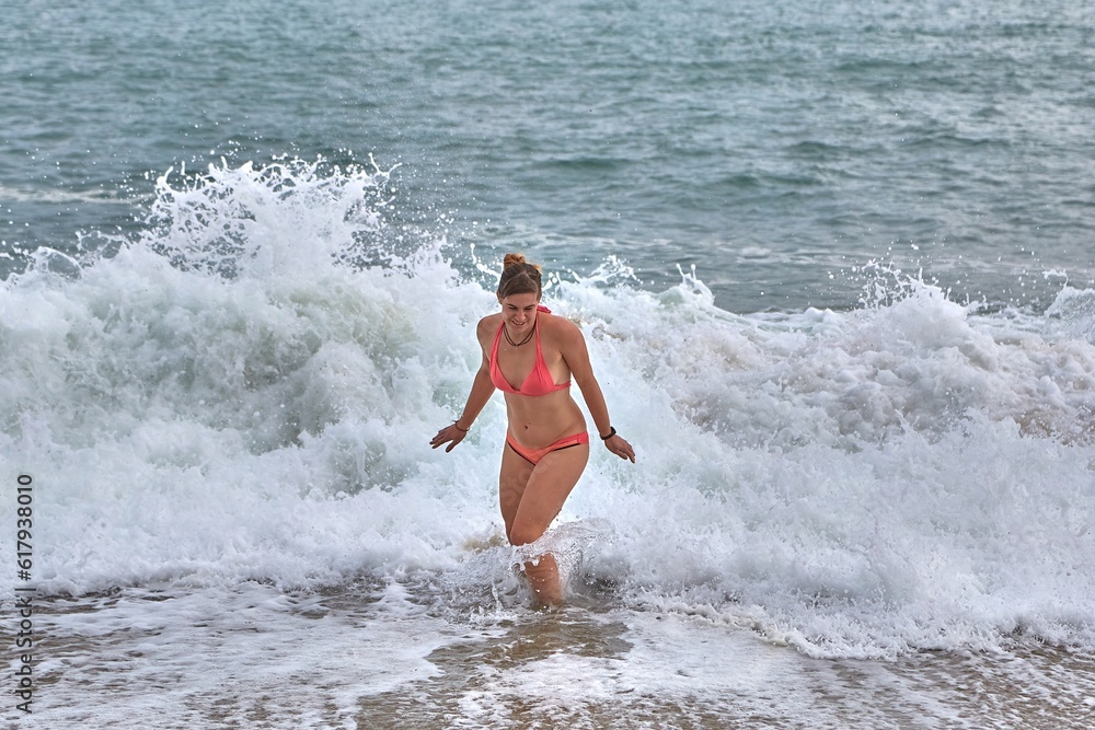Fototapeta premium Playing at the beach with waves