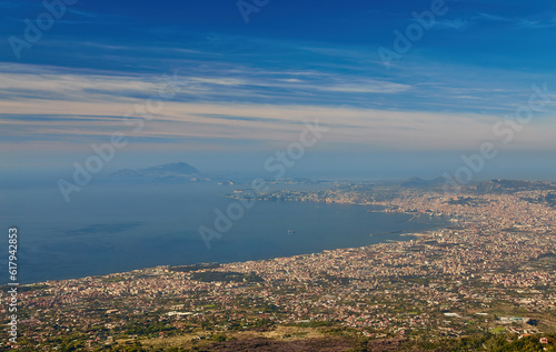 Panoramic view from volcano Mount Vesuvius on the bay of Naples, Province of Naples, Campania region, Italy, Europe. Looking at the island of Capri and Mediterranean coastline on a cloudy day. © Ryzhkov Oleksandr