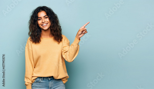 Photographie Young woman pointing finger to side, latin girl isolated on blue