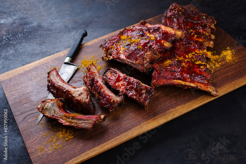 Barbecue veal spare loin ribs St Louis cut with hot honey chili sauce served as close-up on a wooden design board