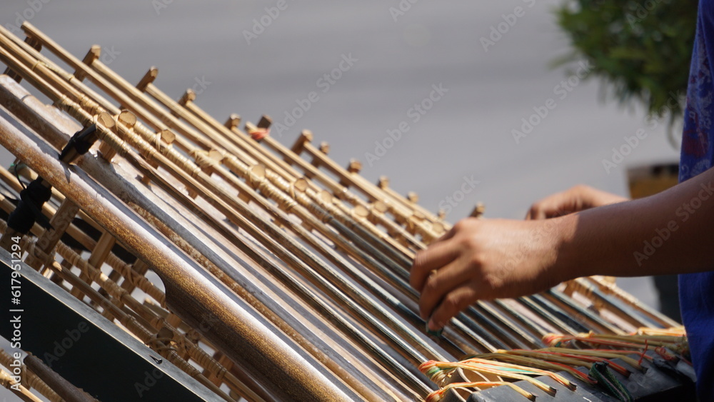 A man is playing angklung. That is a multitonal musical instrument that developed from the Sundanese people. Angklung is made of bamboo A man is playing angklung. That is a multitonal musical instrument that developed from the Sundanese people. Angklung is made of bamboo