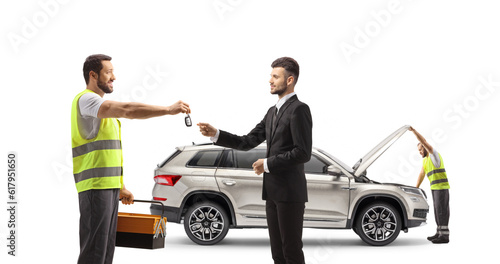 Fotografie Mechanic worker returning car keys to a businessman