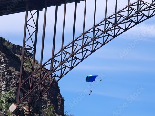 Base jumper parachutes by bridge.