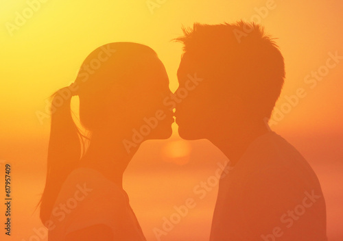Man and woman kissing in the sunlight sunset 