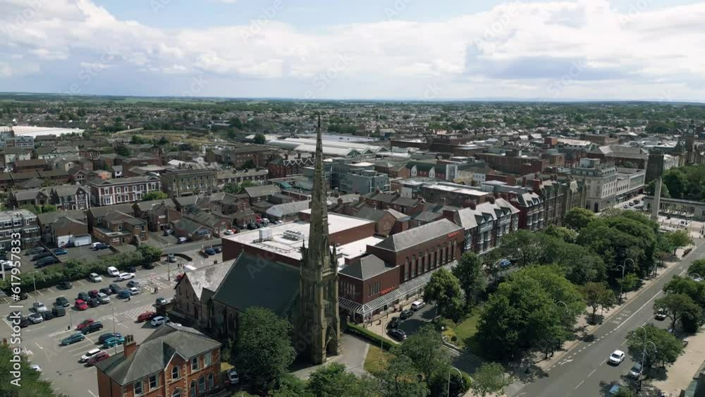 Southport, Lancashire, UK, June 19, 2023; Mid-level aerial orbital clip video footage of St George's URC Church with tall spire on Lord Street in Southport, England Southport, Lancashire, UK, June 19, 2023; Mid-level aerial orbital clip video footage of St George's URC Church with tall spire on Lord Street in Southport, England
