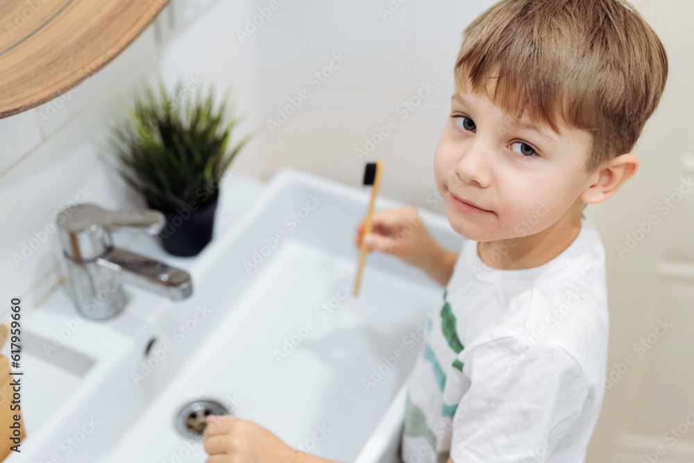 cute 6 years old boy washing his face over the sink in bathroom. Image with selective focus cute 6 years old boy washing his face over the sink in bathroom. Image with selective focus