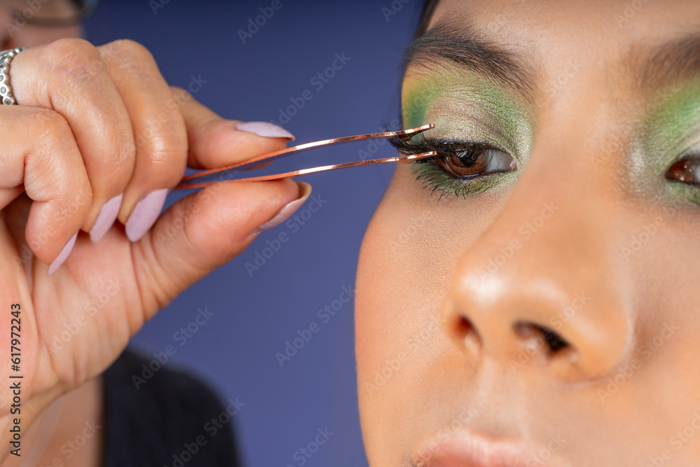 Applying false eyelashes to a young woman