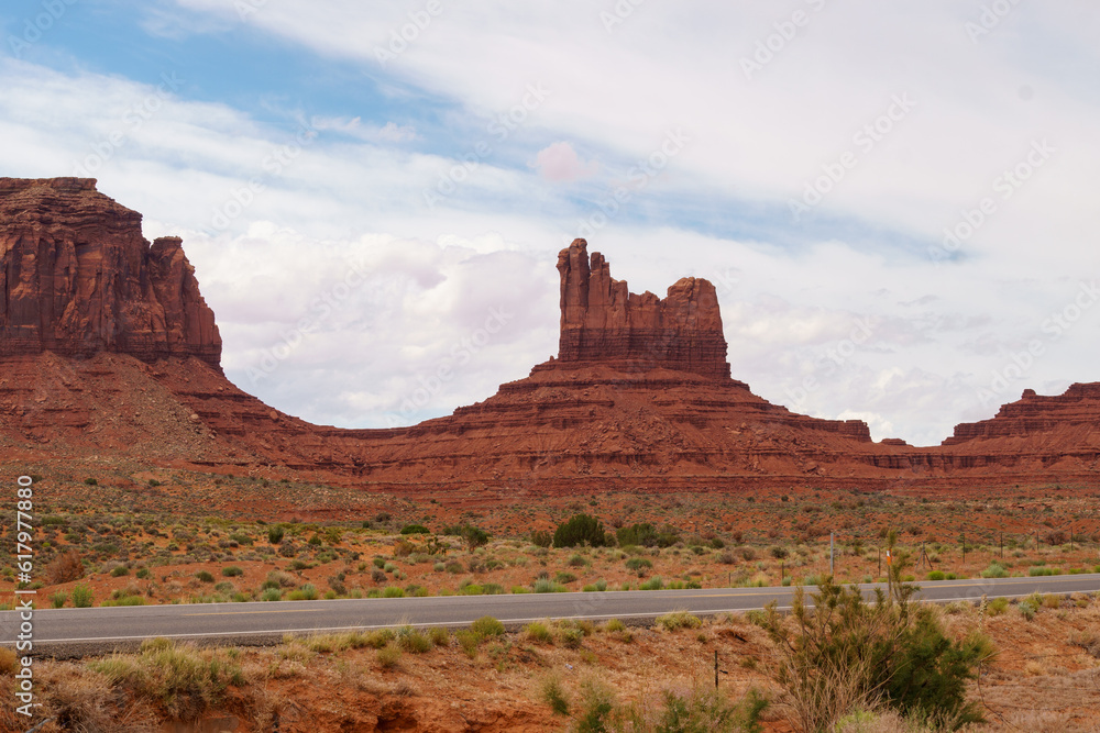 Road through monument valley with sandstone formations in the background