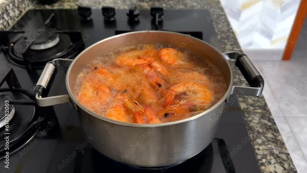 Cooking shrimp on stove in kitchen. Shrimp boiled in a pot on fire. Prepared shrimp in restaurant. Orange red tiger prawns. Sea food prawn background. Mediterranean food. Seafood tiger shrimp Cooking shrimp on stove in kitchen. Shrimp boiled in a pot on fire. Prepared shrimp in restaurant. Orange red tiger prawns. Sea food prawn background. Mediterranean food. Seafood tiger shrimp