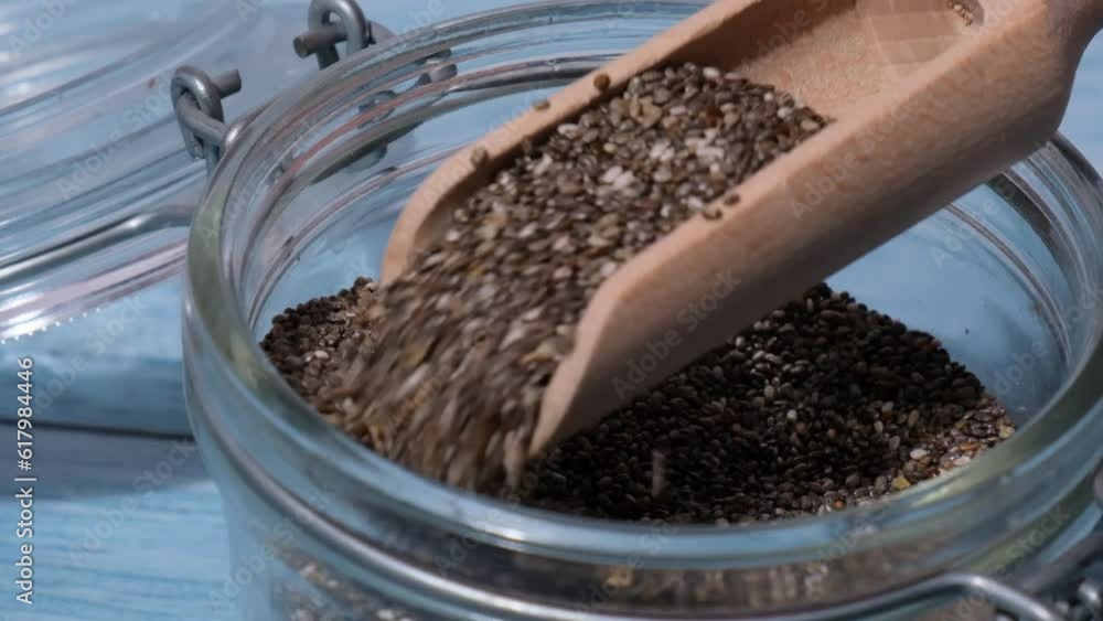 Slow motion chia seeds fall in glass jar. Healthy superfood rich in Omega 3 fatty acids. Dry healthy natural ingredient. Chia grains are falling. Vegetarian food Slow motion chia seeds fall in glass jar. Healthy superfood rich in Omega 3 fatty acids. Dry healthy natural ingredient. Chia grains are falling. Vegetarian food