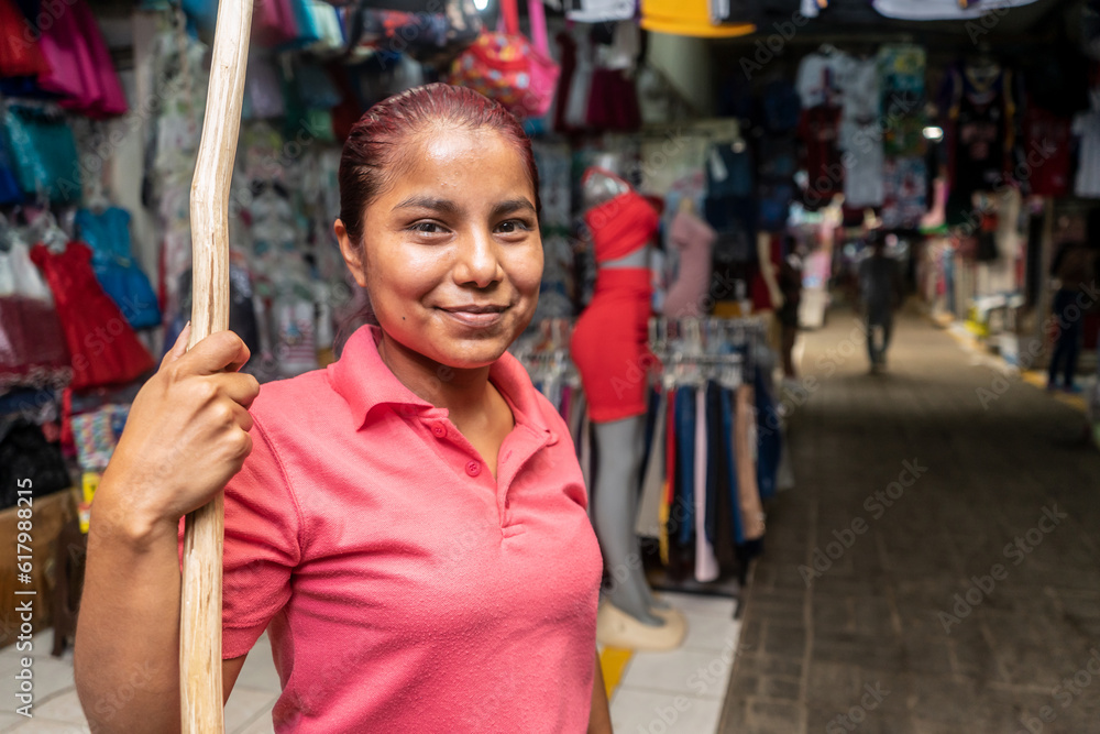 Retailer in front of a stretch of clothing with a wooden stick to place garments at a traditional market in Nicaragua